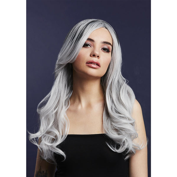 Woman with long silver wavy hair against a dark background