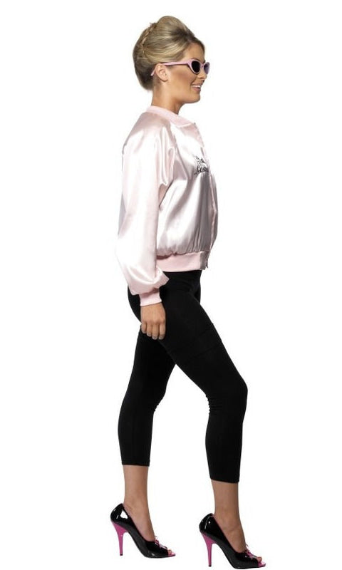Side view of a woman wearing a silky pink ladies Grease jacket with logo stating Pink Ladies