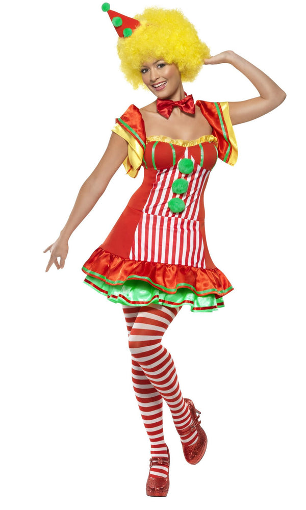 A woman wearing a short red clown dress with green petticoat and hat on headband