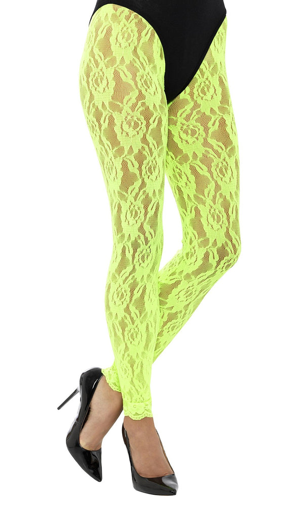 Neon green lace leggings worn with black high heels on a white background