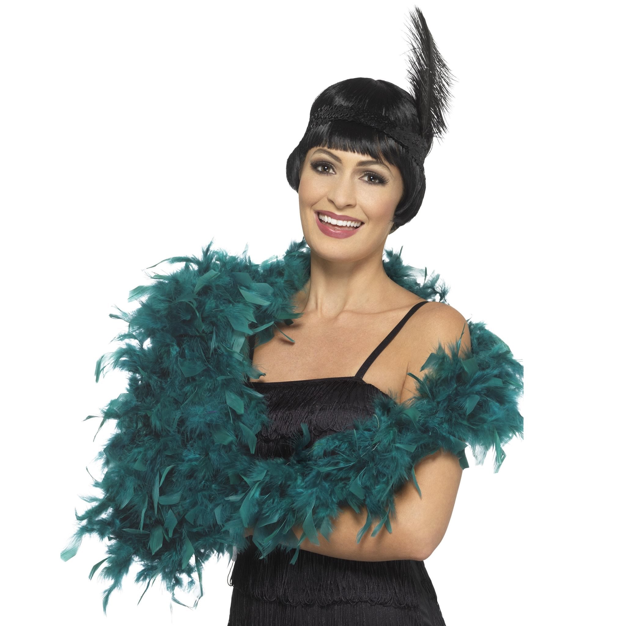 Woman wearing a black dress with a teal feather boa and a black feathered headpiece on a white background