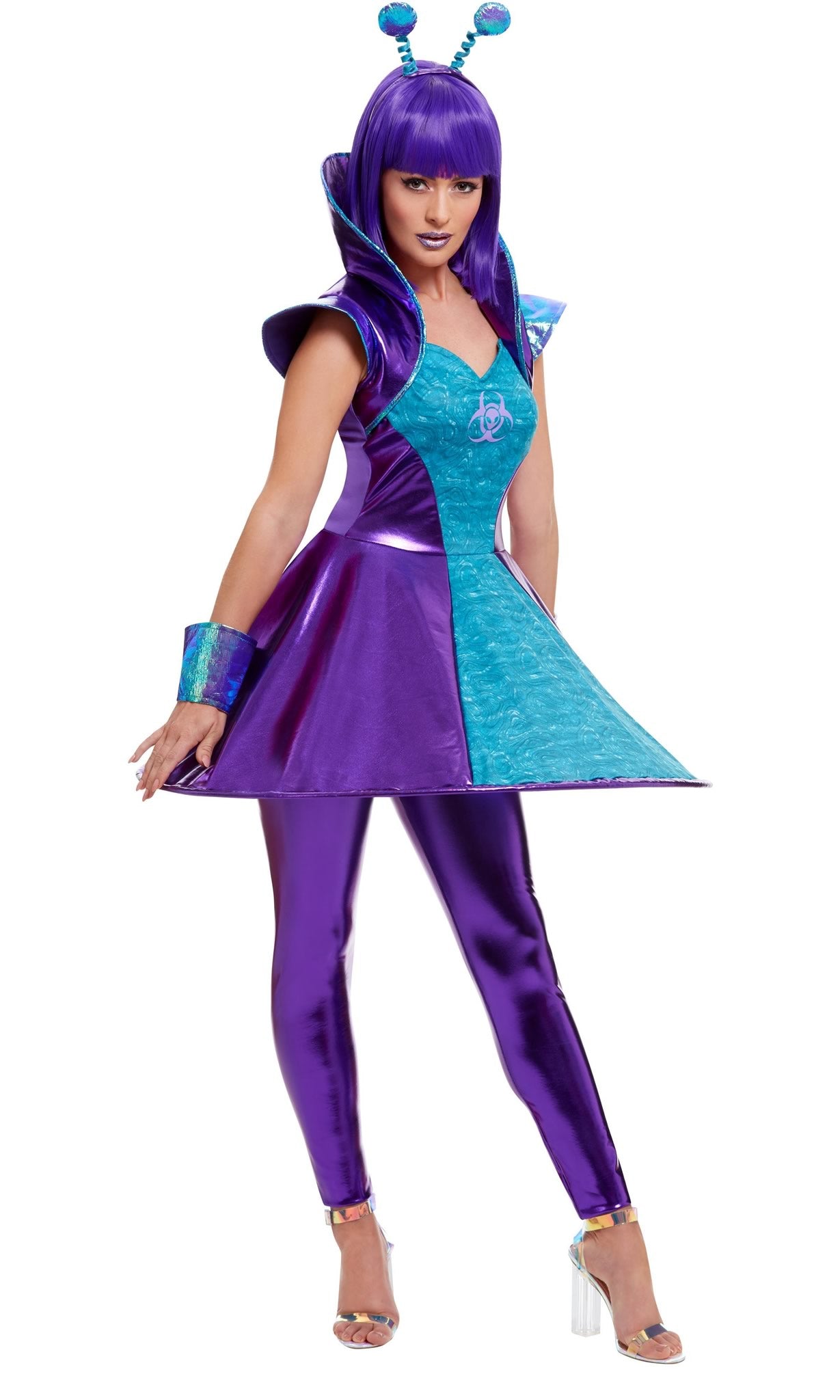 A woman in a space-themed costume with a blue and purple dress, matching leggings, and wrist cuffs, wearing a headband with antenna.