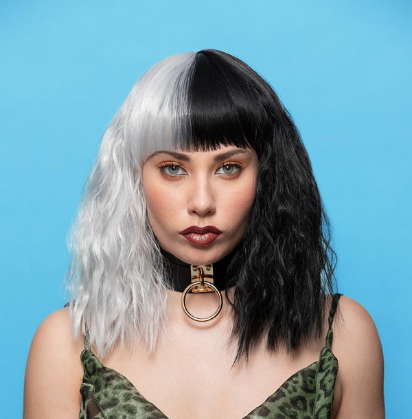 Woman with a black and white wig against a blue background