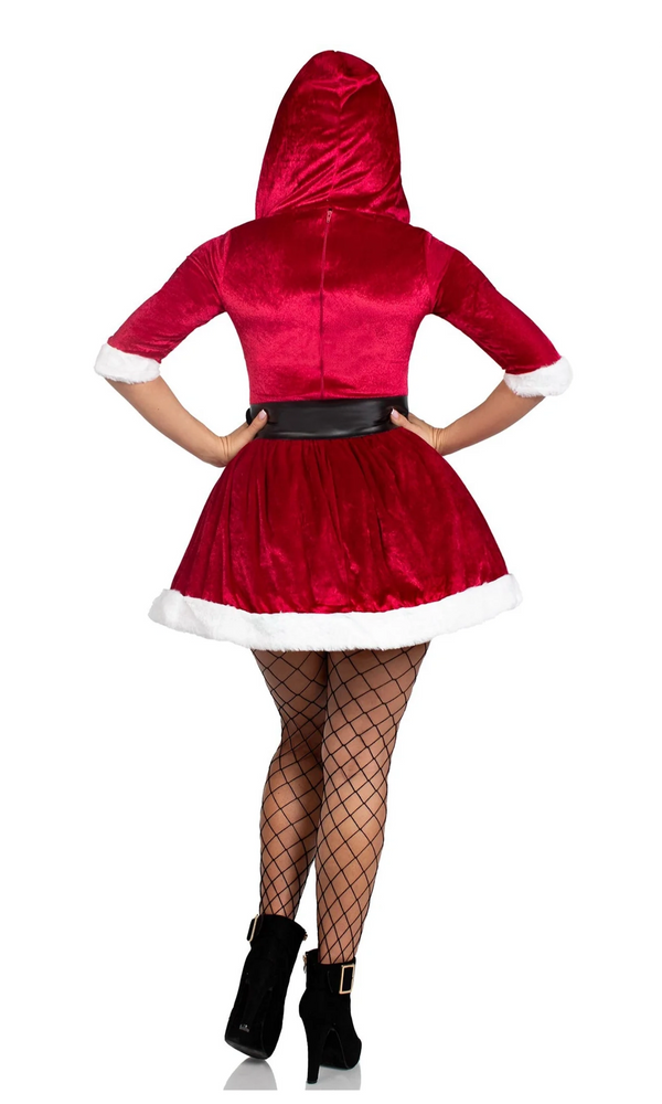 A woman modeling a red velvet Santa-style hooded dress costume from the back, featuring white faux-fur trim, a black faux-leather waist belt, black fishnet tights, and black ankle boots.