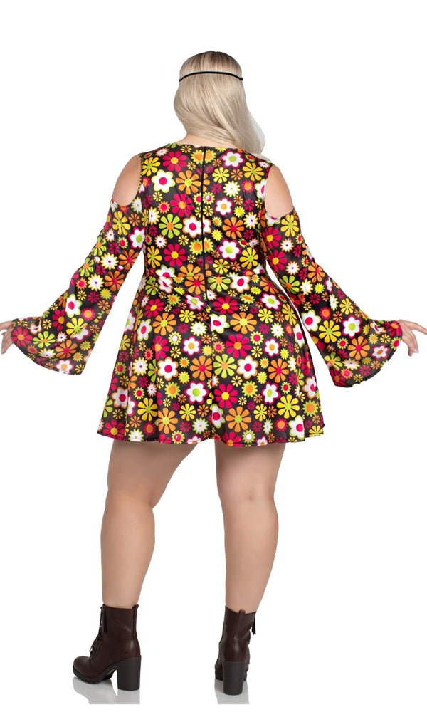 A woman shown from the back wearing a short, cold-shoulder mini dress with a vibrant multicolor retro floral pattern, paired with dark brown ankle boots.