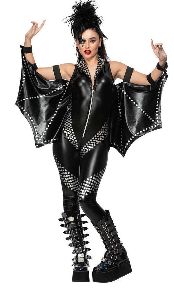 Woman wearing a black leather look Kiss outfit with bat wings and studded details on a white background