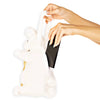 A white plush bunny handbag with gold accents, shown with a person's hands holding a phone inside its side pocket.