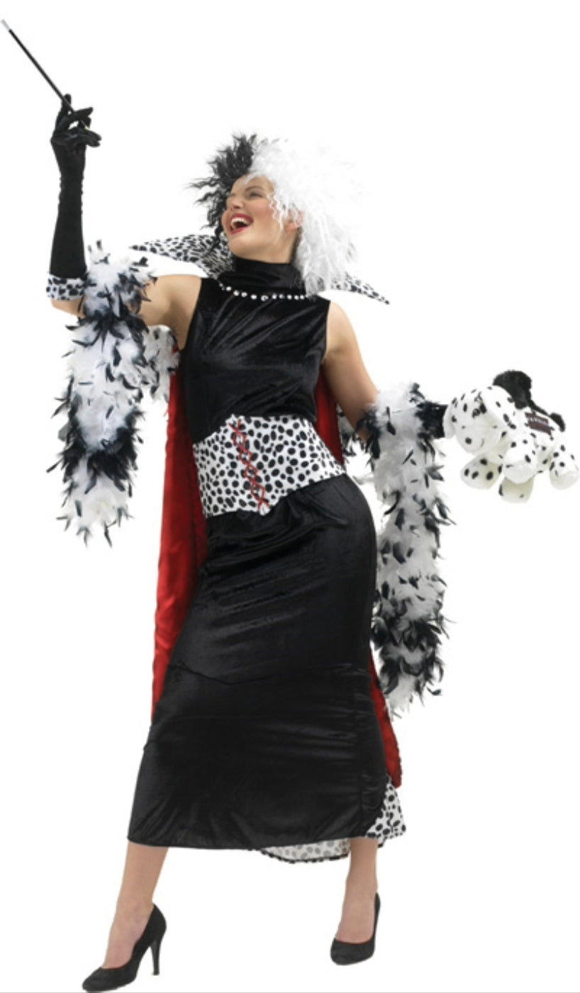 A woman wearing a Cruella De Vil costume, featuring a black and white dress with dalmation print, gloves, a cape, and a wig.