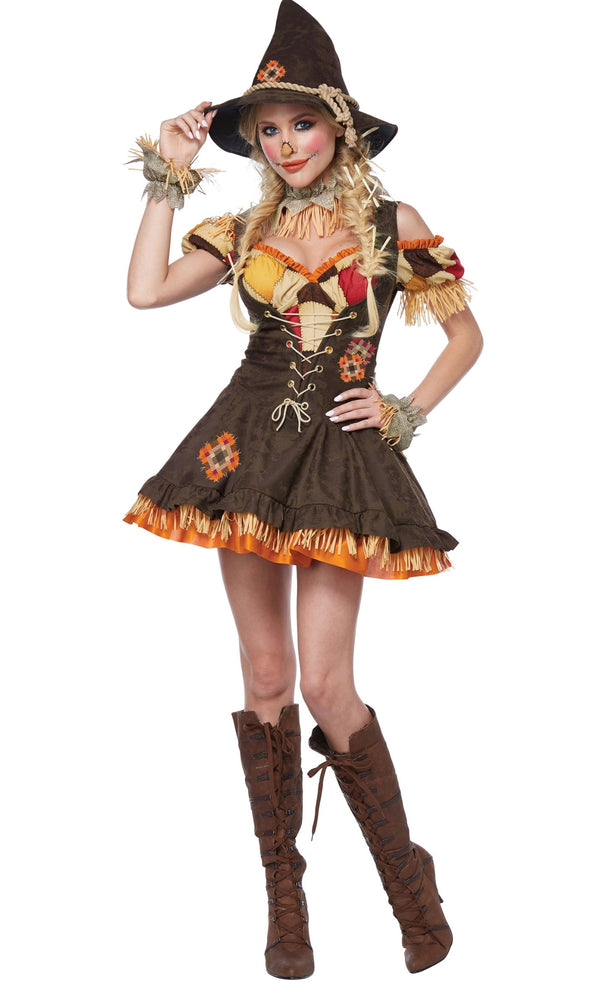 A woman modeling a scarecrow costume. The costume includes a brown hat with a straw band, a brown corset-style top with straw sleeves and orange floral accents, a matching skirt with straw trim, and tall brown lace-up boots.