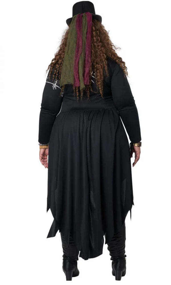 A woman shown from the back wearing a black gothic costume with a long skirt, black top, black boots, and a black hat with green and burgundy hair ribbons.