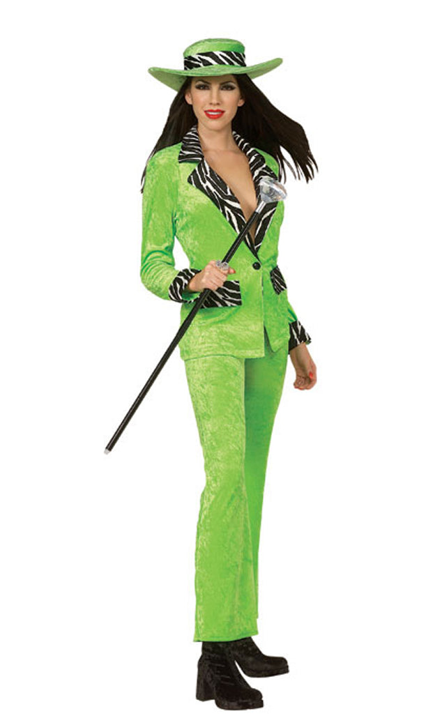 A woman wearing a green costume with a jacket, pants, and a hat, holding a cane, portraying a stereotypical pimp character.