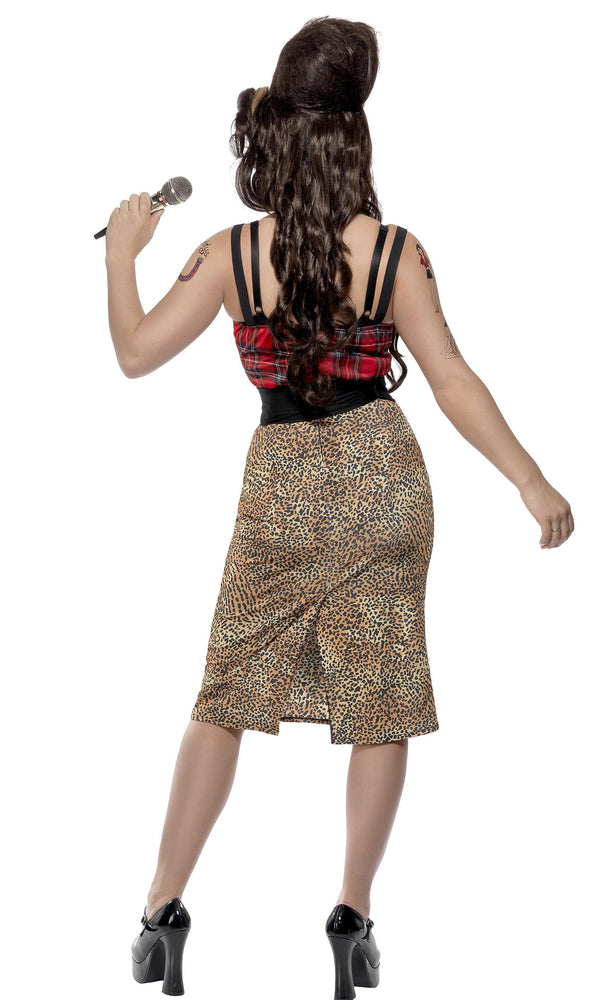 Back view of a woman wearing a costume designed to resemble Amy Winehouse, featuring a leopard print dress with a tartan top and high heels.