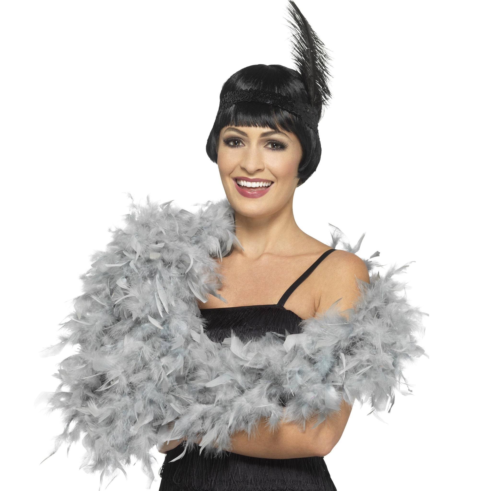 A woman wearing a black flapper style dress and a sliver feather boa.