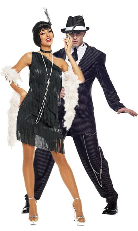 Off one shoulder short black flapper dress with tassels, headband, choker, pearl necklace and boa next to male gangster